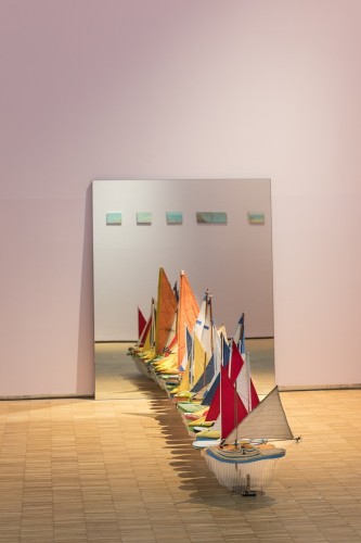 Terra inquieta, veduta della mostra (Francis Alÿs, Untitled (Studio per / Study for Don't Cross the Bridge Before You Get to the River), 2006-2009, installation composed of thirty shoe-boats and one mirror: glass, leather, wood, foam, thread, plastic, corrugated plastic, fabric and steel, 120x100x325.4 cm Courtesy Francis Alÿs and David Zwirner, New York/London), La Triennale, Milano © Foto Gianluca Di Ioia